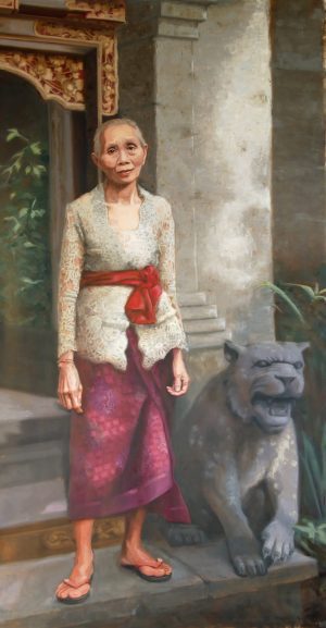 A Balines woman in front of a hotel welcoming her guests, near a pilar and grey lion statue